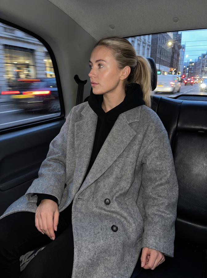 Grey wool coat in the back of a taxi