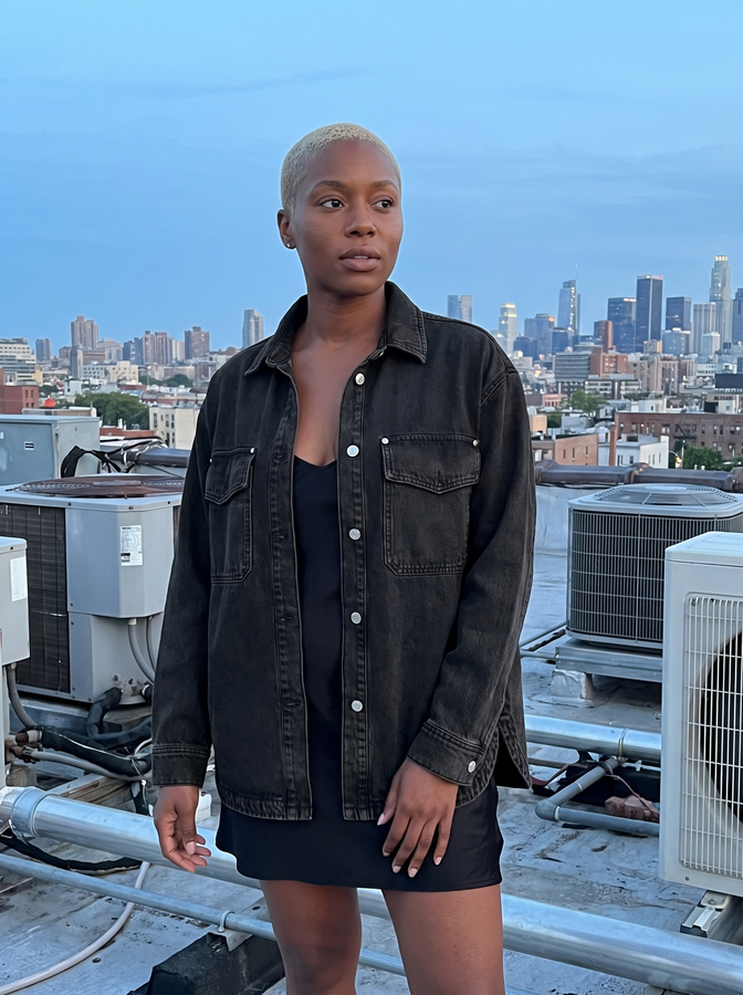 Black denim shirt-jacket on a city rooftop at dusk