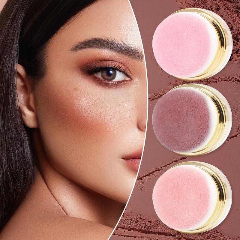 Woman with a warm blush on her cheek next to the three puff applicators seen from above