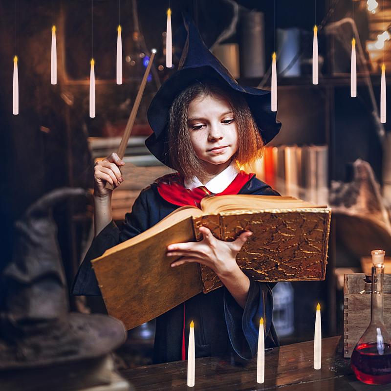 Child in a wizard costume reading under floating candles