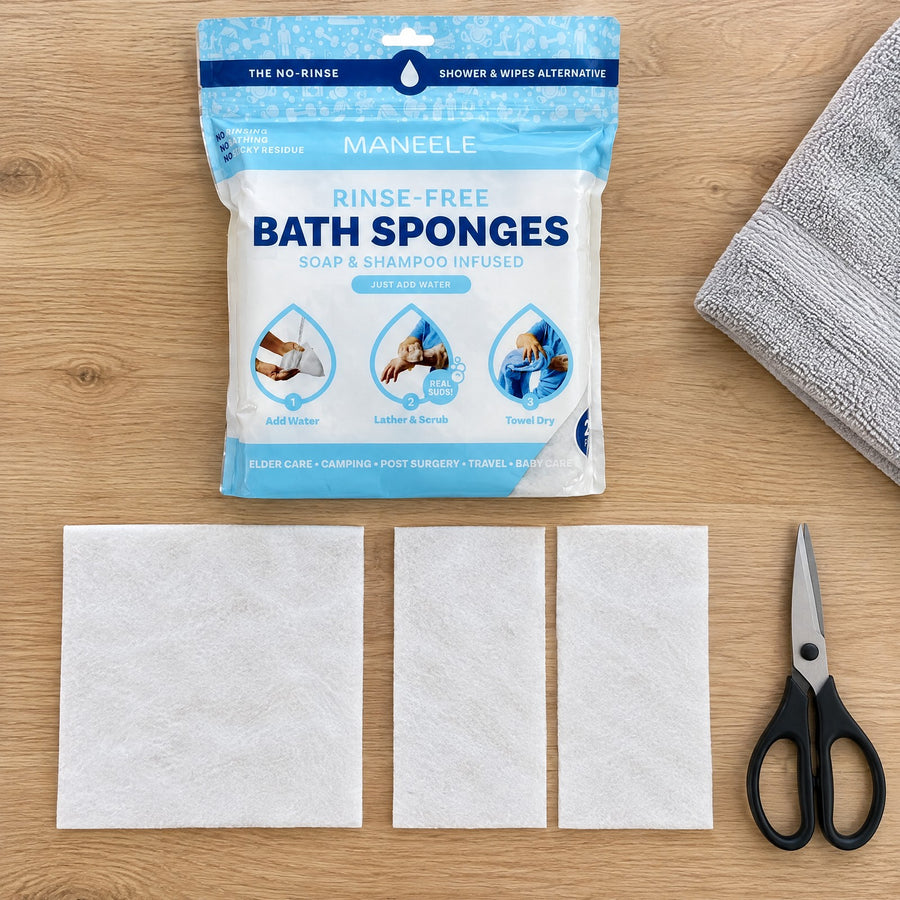 Overhead view of the Maneele pouch with one whole rinse-free bath sponge and a second one cut in half, scissors and a grey towel beside them