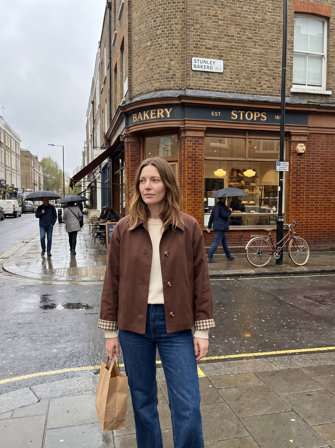 Dark brown cropped trench outside a bakery