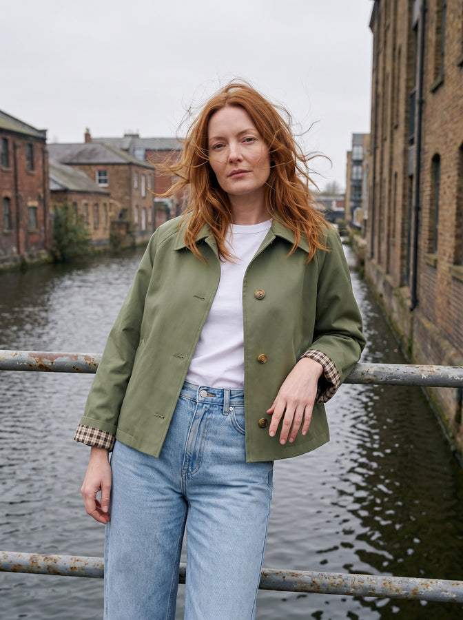 Olive green cropped trench by a canal